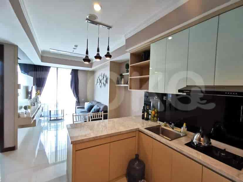A kitchen with light wooden cabinets, a marble countertop, and stainless steel appliances.