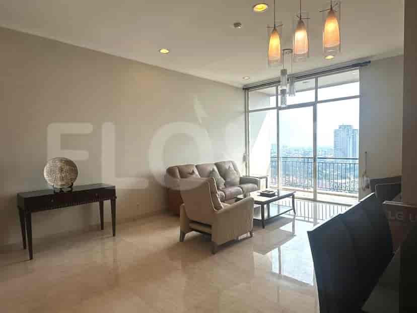 A living room with a sofa, armchair, coffee table, and a large window overlooking a city view.