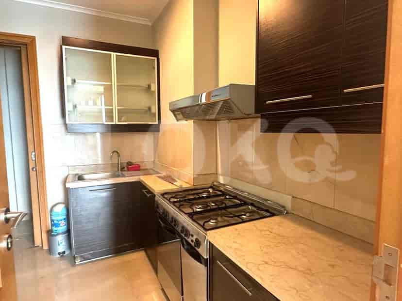 A compact kitchen with dark wood cabinets, a gas stove, and a marble countertop.