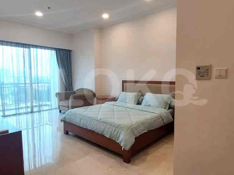 Kamar tidur dengan tempat tidur besar berseprai biru muda dan jendela dengan gorden.