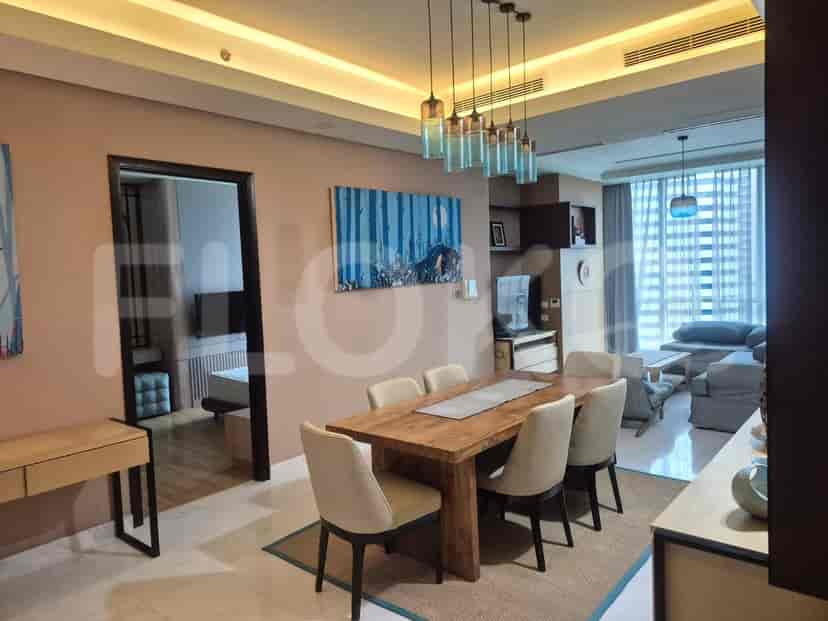 A dining room with a wooden table, four chairs, and a decorative wall art.