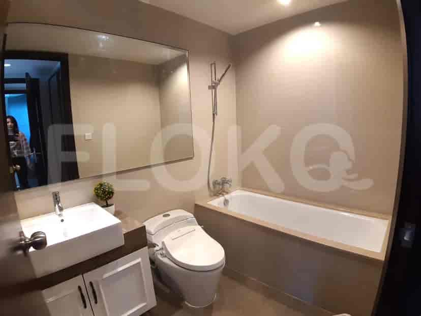 Kamar mandi kontemporer yang menampilkan wastafel putih, toilet dengan fungsi bidet, dan bak mandi.