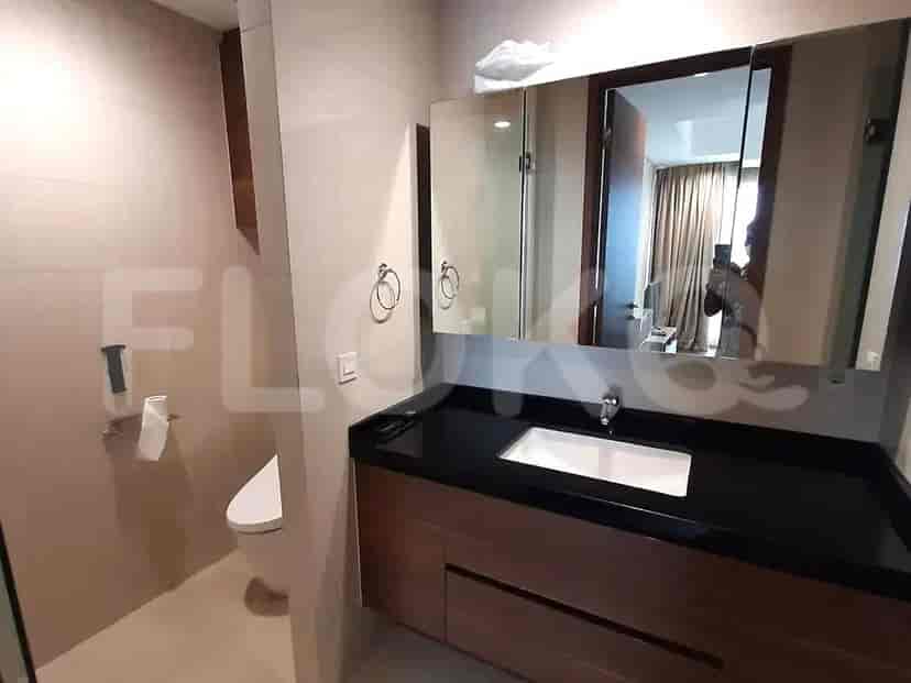 Sebuah kamar mandi modern dengan meja rias, wastafel, toilet, dan lemari obat bercermin.