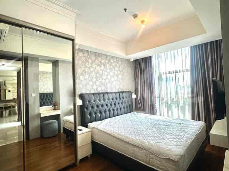 Kamar tidur utama dengan tempat tidur besar, lemari cermin, dan area meja rias.