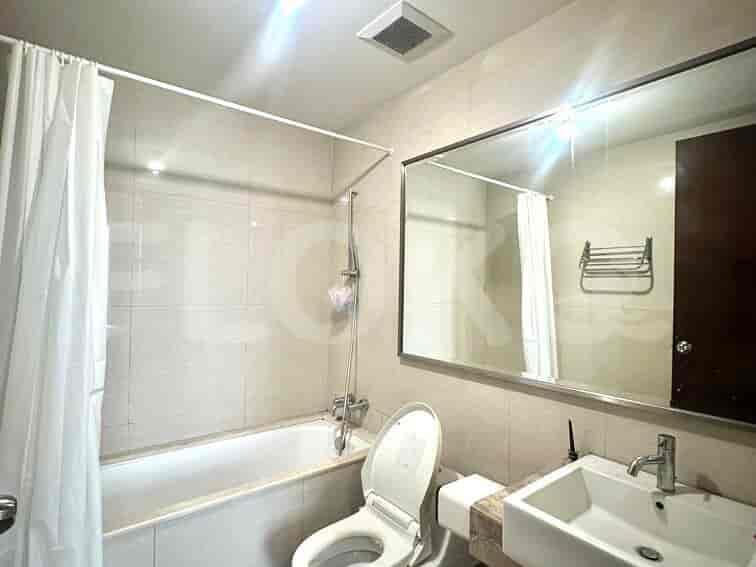 Kamar mandi dengan bak mandi, toilet, wastafel, dan cermin besar.