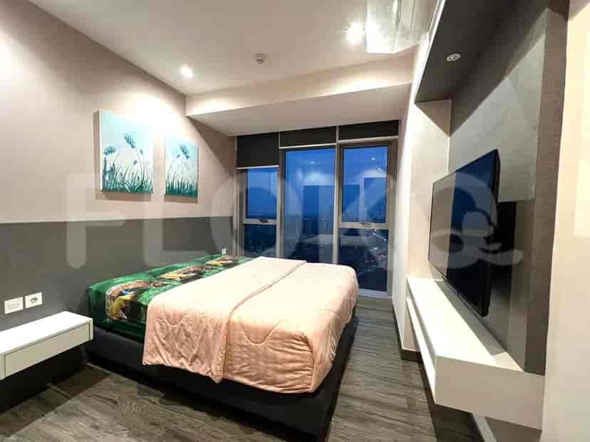 Sebuah kamar tidur yang nyaman dengan tempat tidur ukuran queen, TV yang terpasang di dinding, dan jendela besar dengan pemandangan kota.