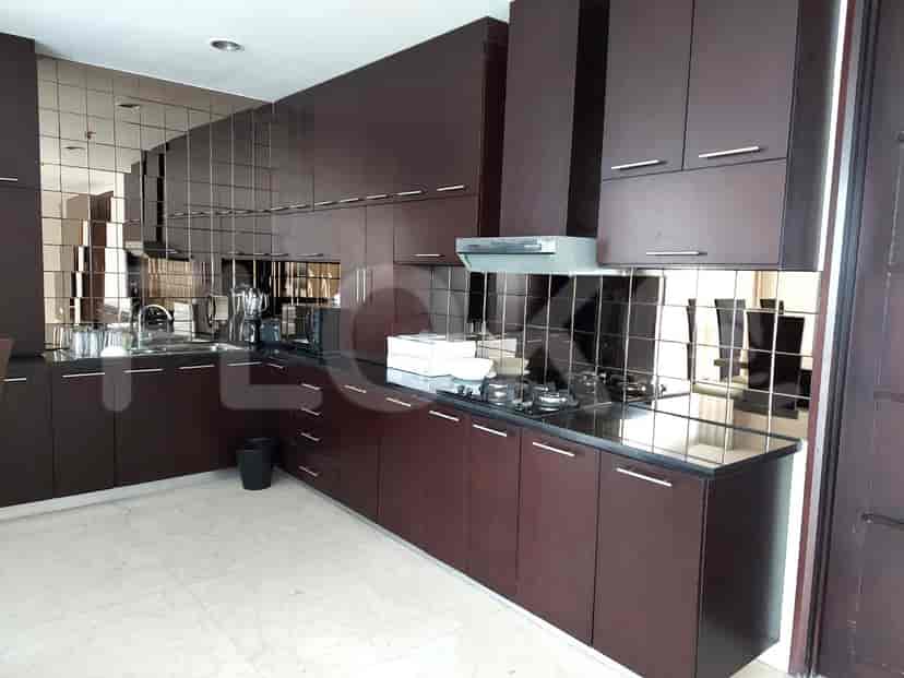 A modern kitchen with dark wood cabinets, granite countertops, and a mirrored backsplash.
