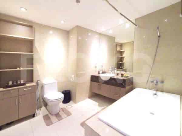 A clean and modern bathroom featuring a bathtub, sink, toilet, and ample storage.