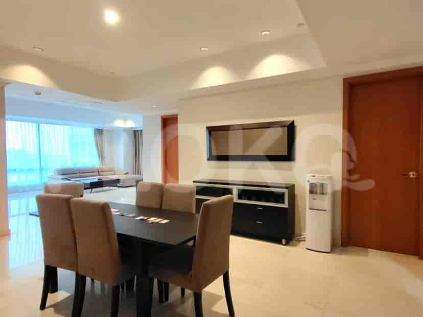A dining area with a table and chairs, a sideboard, and a water dispenser, adjacent to the living room.