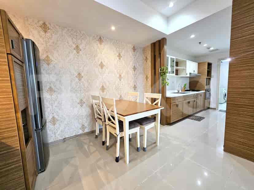 A dining area with a table and chairs adjacent to an open kitchen.