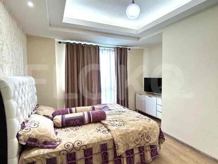 Master bedroom with a queen-sized bed, television, and window with curtains.