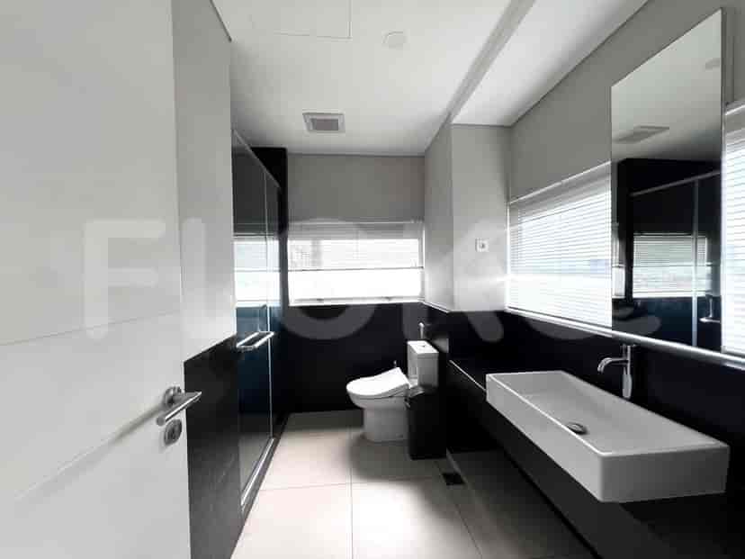 A modern bathroom featuring a floating vanity with a vessel sink, a toilet, and a glass-enclosed shower.