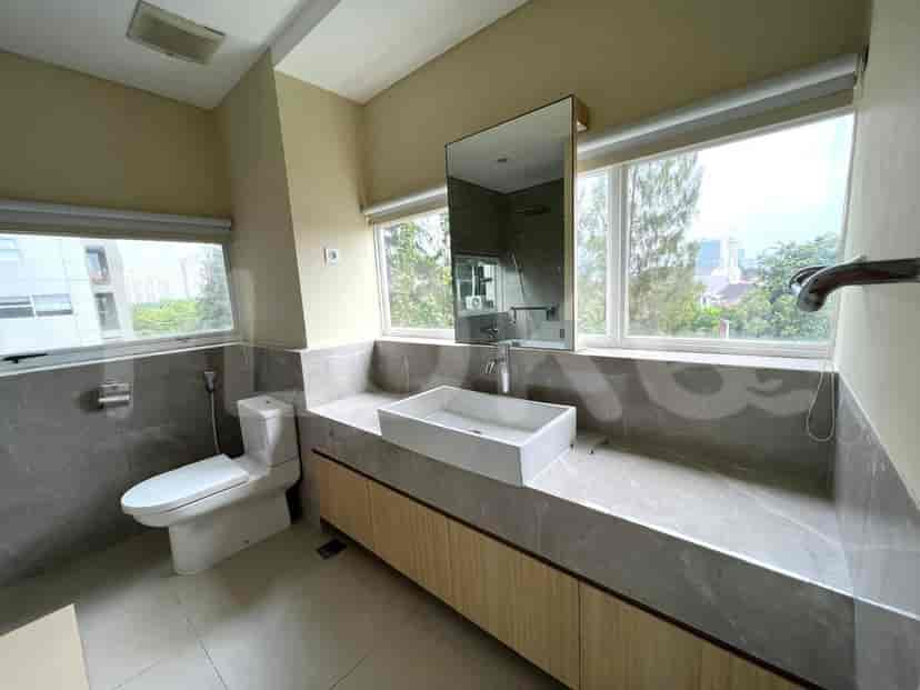 Sebuah kamar mandi modern dengan vanity gantung, wastafel gantung, toilet, dan jendela besar.