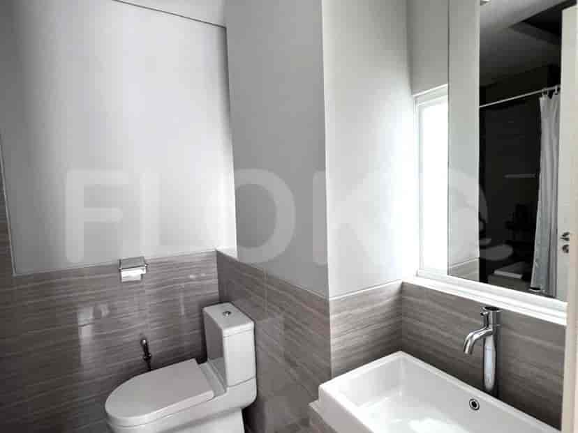 Kamar mandi dengan toilet, wastafel, dan cermin.