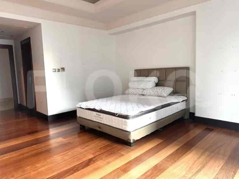 Kamar tidur dengan tempat tidur ukuran queen, lantai kayu, dan dinding putih.