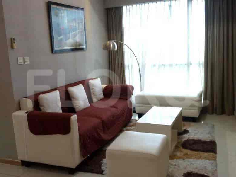 Sebuah ruang tamu dengan sofa merah dan putih, meja kopi, lampu lantai, dan jendela besar dengan gorden.