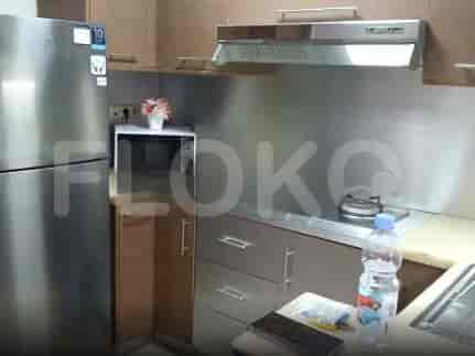 A kitchen with a refrigerator, microwave, stove, and cabinets.