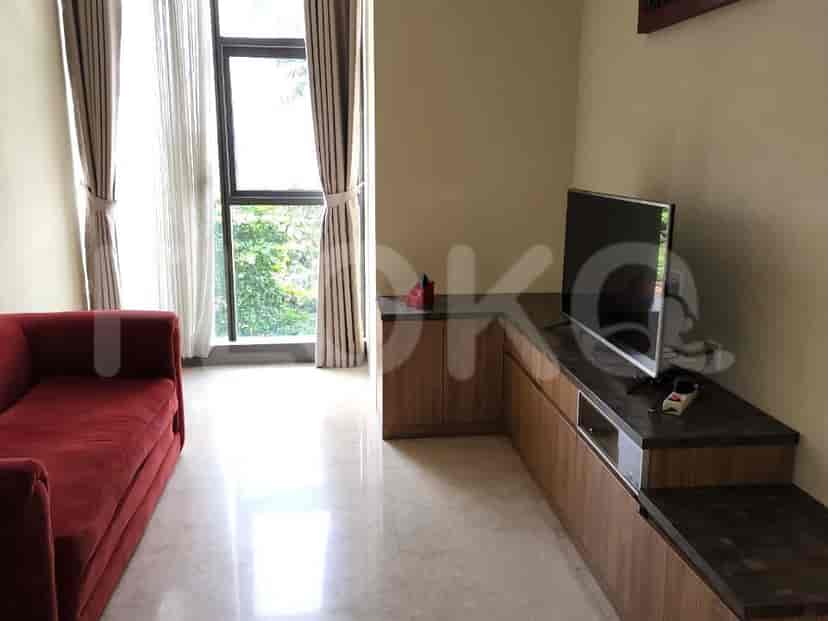 Living room with a red sofa, wooden entertainment unit, and a large window.