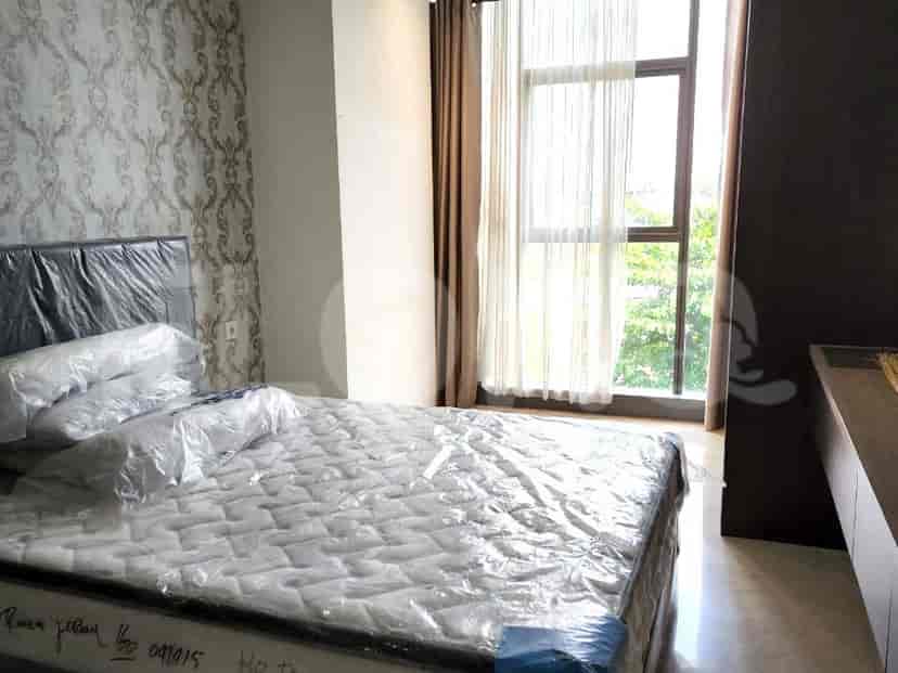 Bedroom with a bed covered in plastic, a large window with curtains, and patterned wallpaper.
