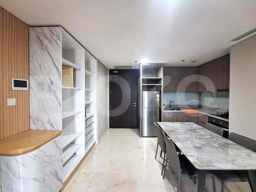 An open-concept space combining a dining area with a marble-topped table and chairs, and a modern kitchen equipped with stainless steel appliances.