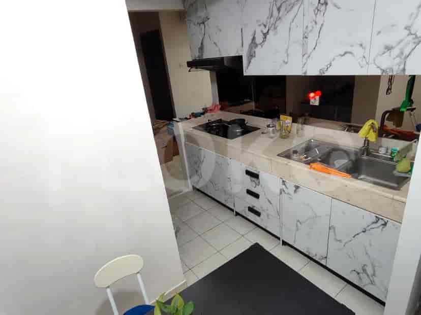 A kitchen with marble-patterned cabinets, a sink, and a stove.
