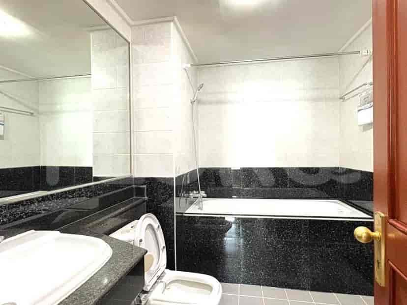 A bathroom with a sink, toilet, and bathtub, featuring black granite accents and white tiled walls.