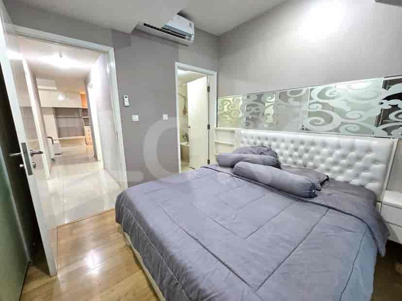 Sebuah kamar tidur utama dengan tempat tidur ukuran king, kepala tempat tidur berumbai, dan pemandangan ke lemari pakaian.