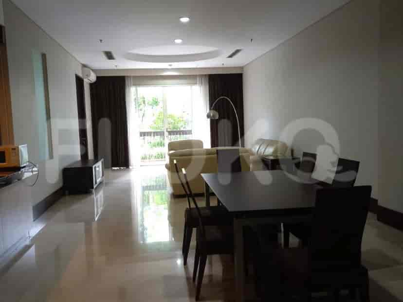 A spacious living and dining area with a large window, sofa, dining table, and light marble flooring.