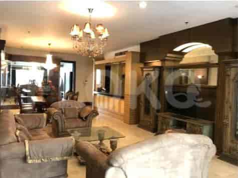 A luxurious living room with plush sofas, a glass coffee table, and an ornate chandelier.