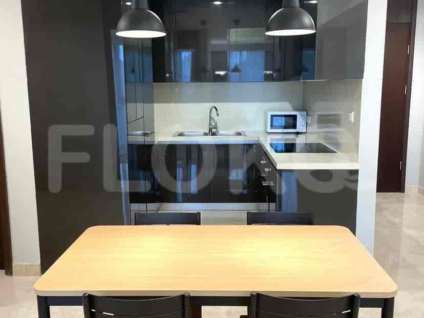 A modern kitchen with black cabinets, a sink, microwave, and a dining table.