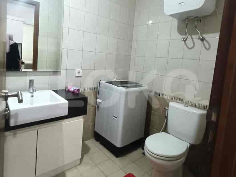 A compact bathroom with a white sink, toilet, and a washing machine.