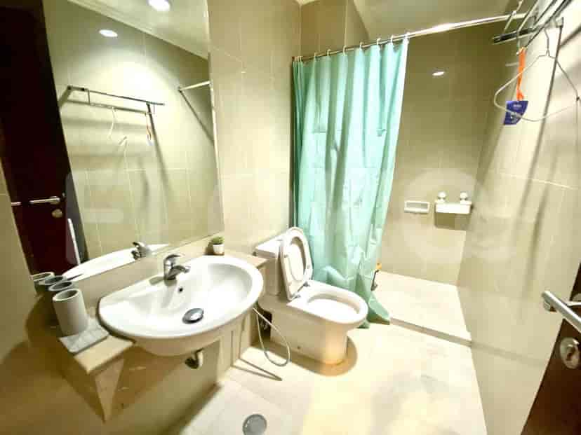 A bathroom with a sink, toilet, and a shower area enclosed by a curtain.