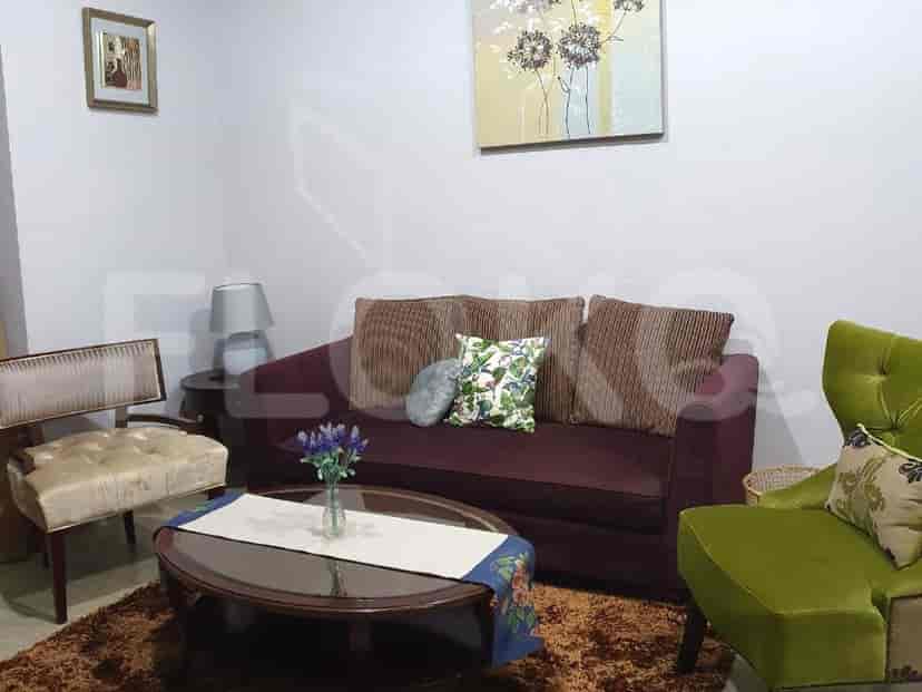 A cozy living room with a dark red sofa, accent chairs, and a coffee table.