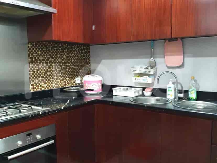 A compact kitchen with dark wood cabinets, a granite countertop, and stainless steel appliances.