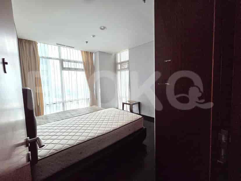 A bedroom with a large bed and floor-to-ceiling windows.
