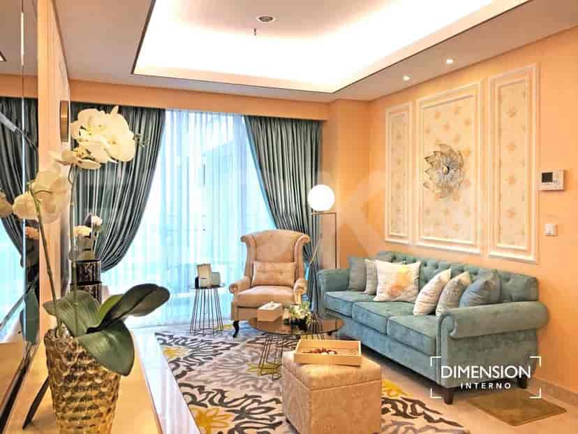A luxurious living room with a teal sofa, armchair, ornate rug, and decorative wall panels.
