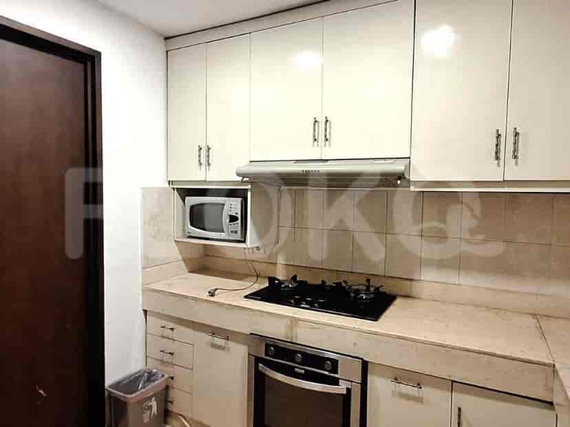 A kitchen with white cabinets, a gas stove, oven, and microwave.