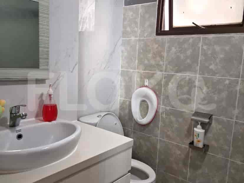 A bathroom with a sink, toilet, and tiled walls.