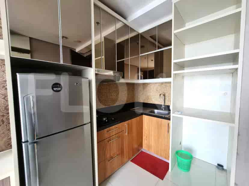 A compact kitchen with a refrigerator, stovetop, sink, and ample cabinet space.