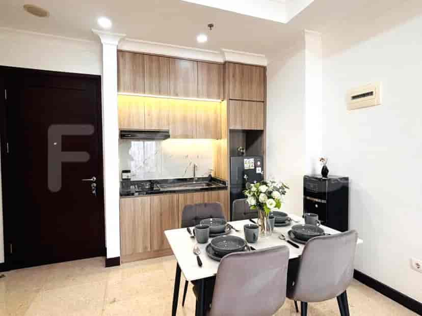 Dapur dan ruang makan yang ringkas dengan meja makan yang ditata untuk empat orang dan lemari dapur modern.