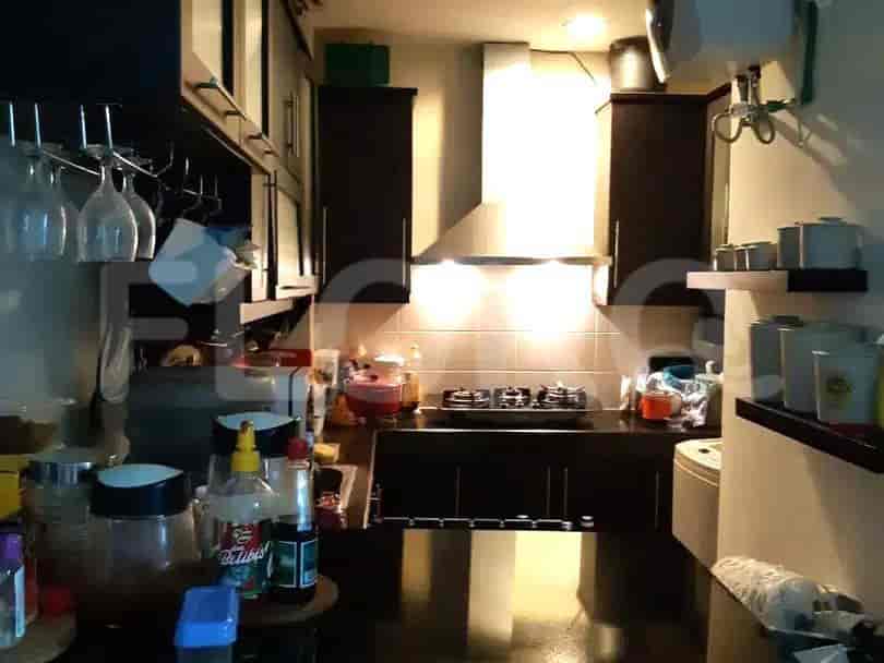 A compact kitchen with dark wood cabinets, a stainless steel chimney, and a gas stove.