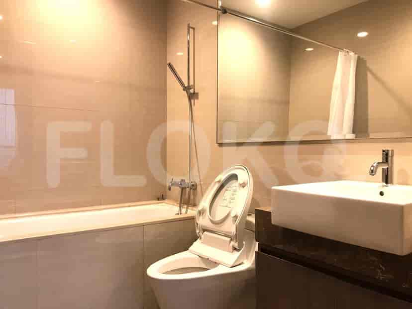 Kamar mandi modern dengan bak mandi, toilet, wastafel, dan cermin.