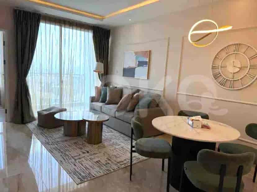 A living room with a sofa, coffee tables, a dining table, and a large window.