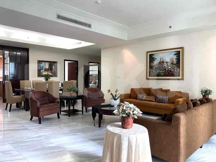 A spacious living room with comfortable seating, a dining area, and a large painting on the wall.