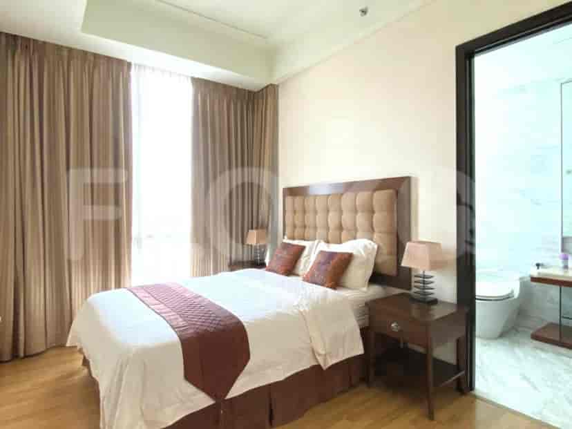 A bedroom with a queen-size bed, nightstand, and a view of the en-suite bathroom.