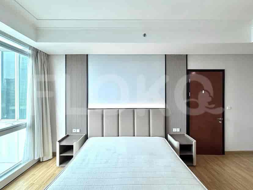 A bedroom with a large bed, nightstands, and a window.