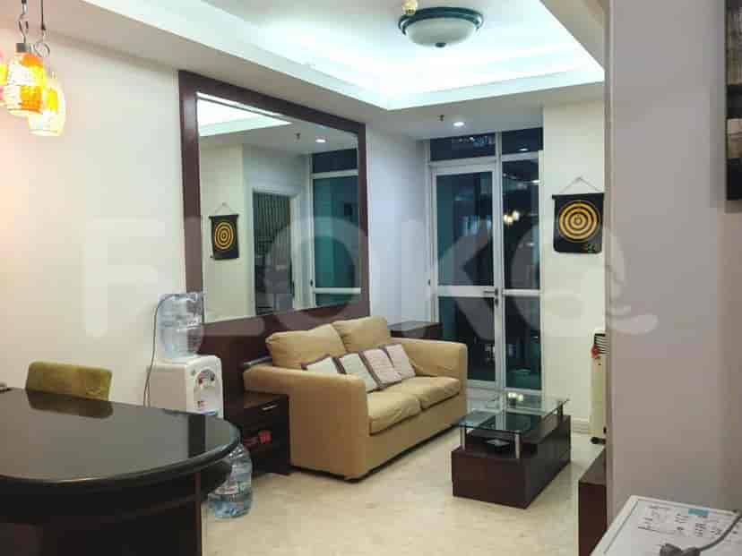 A living room with a beige sofa, coffee table, and a large mirror.