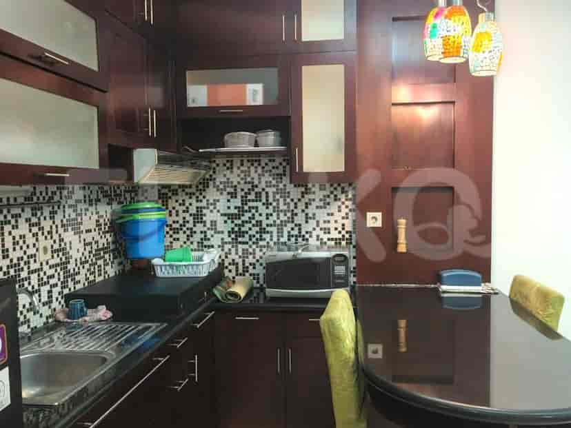 A kitchen with dark wood cabinets, a mosaic backsplash, and a dining table.