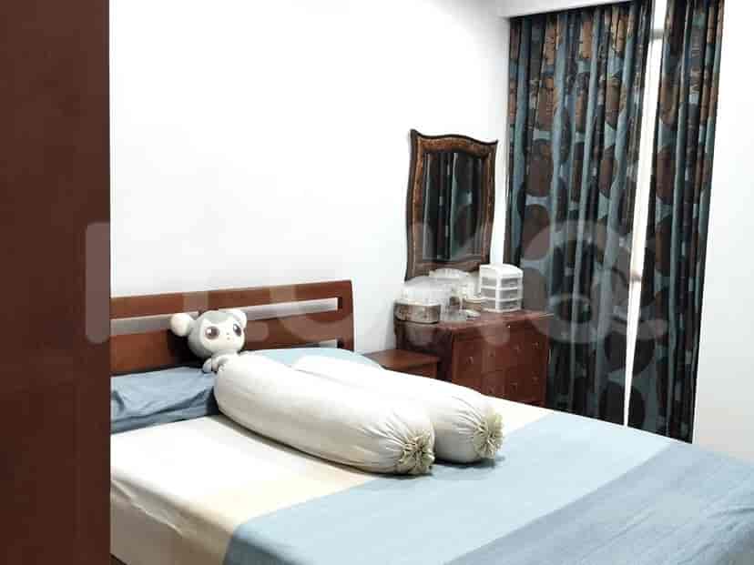 A bedroom with a bed, a dresser with a mirror, and patterned curtains.