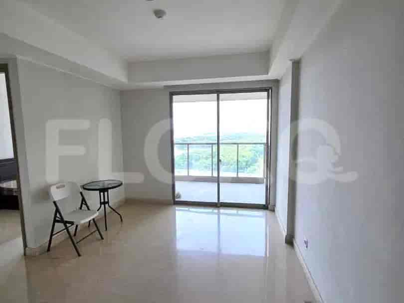 A bright living room with large glass sliding doors leading to a balcony, featuring a small table and two chairs.